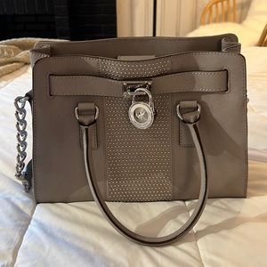 Michael Kors bag with silver stud detailing and signature MK logo lock.